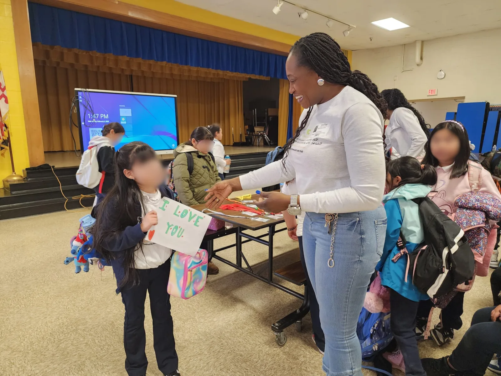 Young participant receiving a graduation certificate and gift