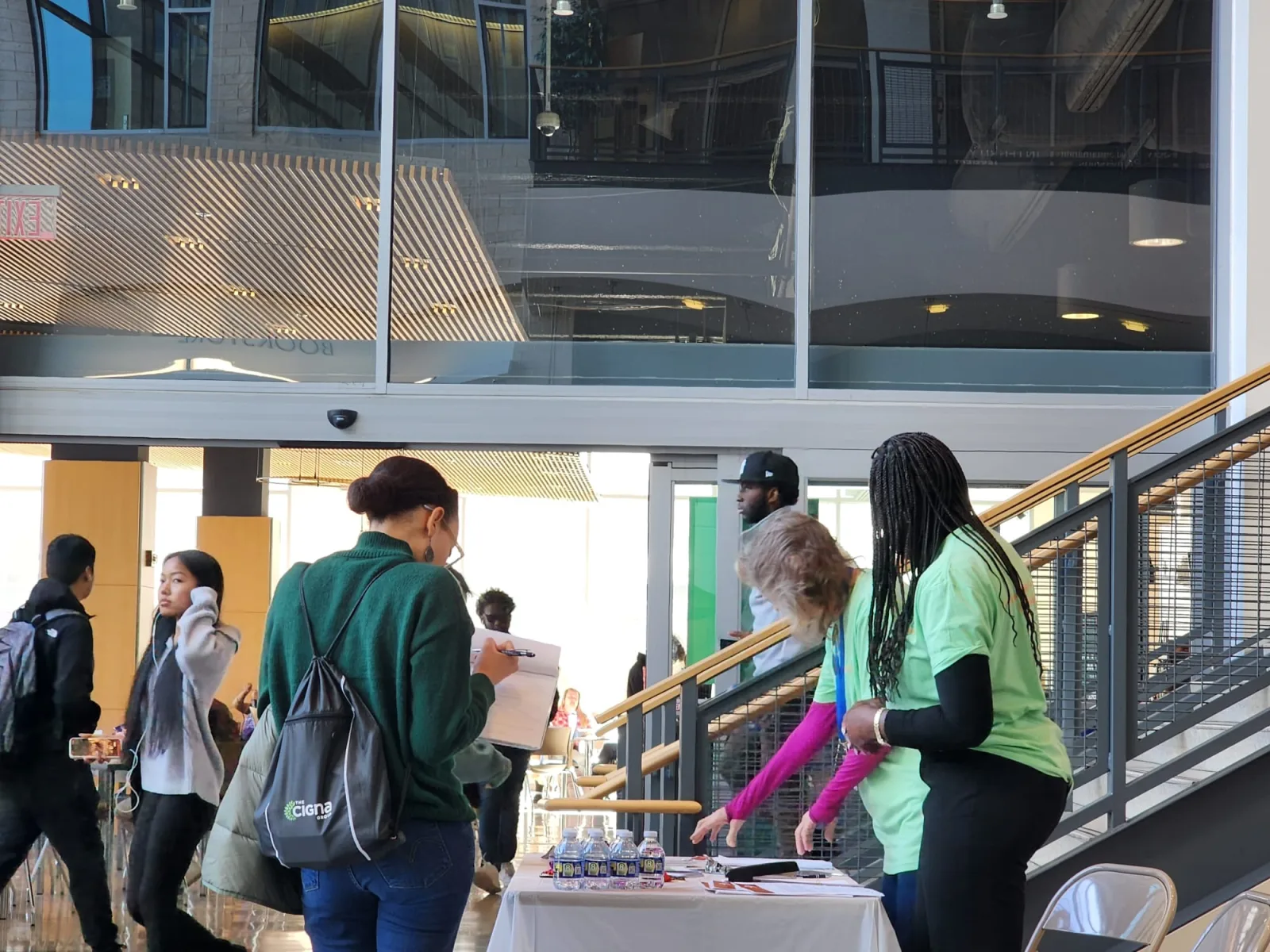 Students speaking with representatives at a job fair information table