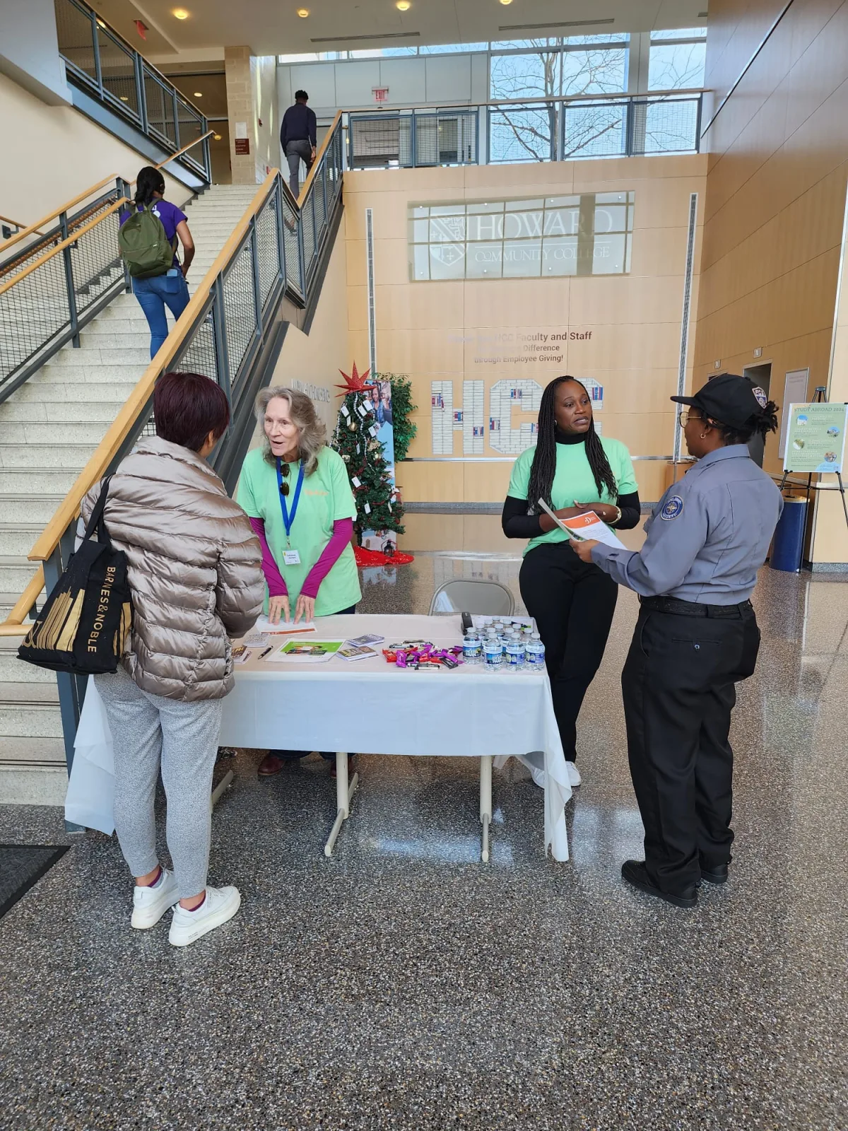 Visitor speaking with representatives at an R1YC information table