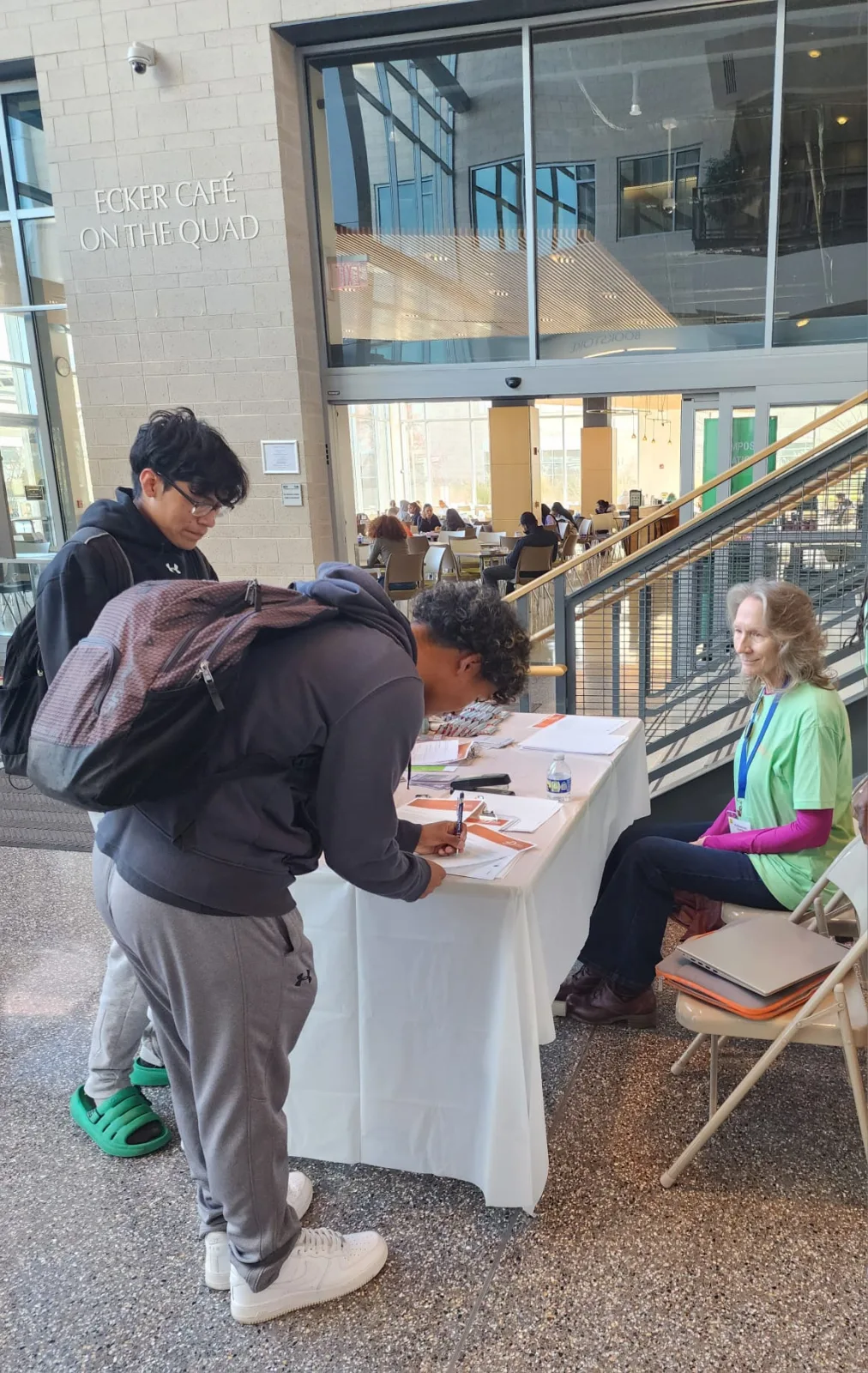 Community member checking in at the program information table