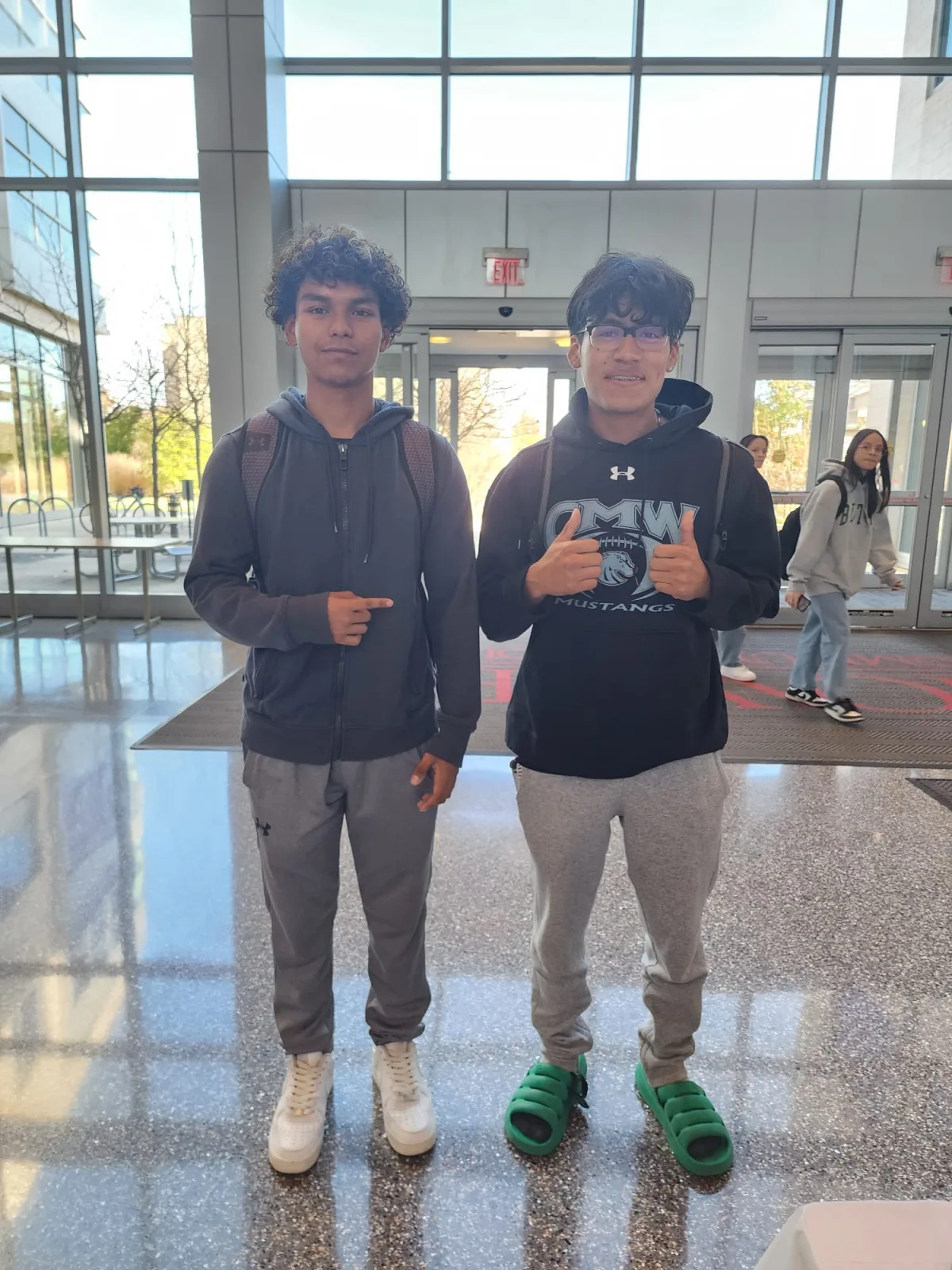 Two young volunteers holding program materials