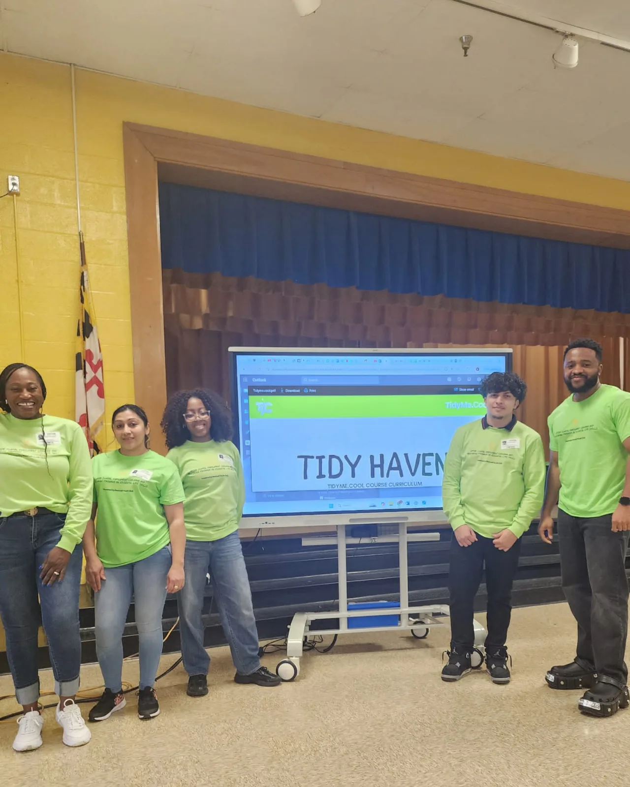 Program facilitators gathered beside a Tidy Habits presentation screen